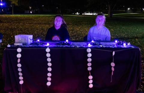 Two student volunteers tabling at dusk for take back the night