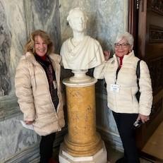 ARA members Joanne Boyle and Membership Director Linda Lacroix pose with a statue of Cornelius Vanderbilt, builder and owner of The Breakers. 