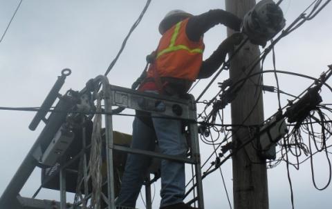 New Hampshire Now project worker lashing wires to poles