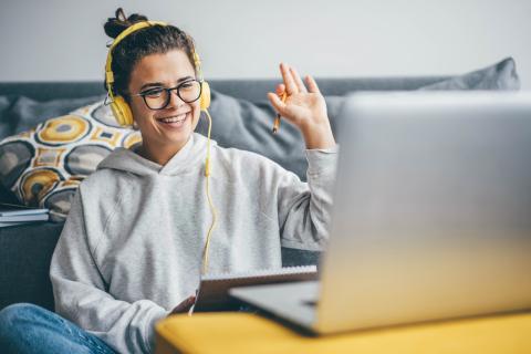 Student raises hand in front of computer