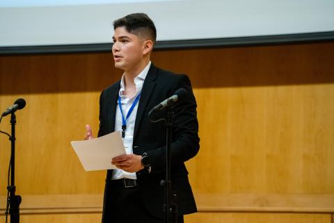 Man stands on front of stage presenting