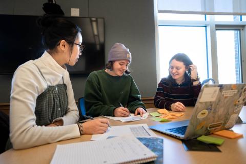 Students collaborate at a desk