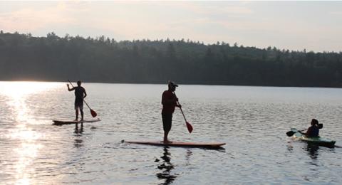 People paddle boarding at Mendums Pond