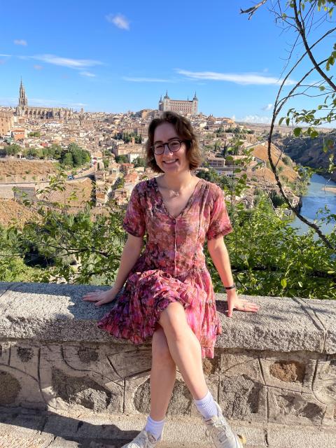 Student sitting on wall, overlooking city