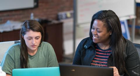 Photo of a faculty member and a student in a classroom