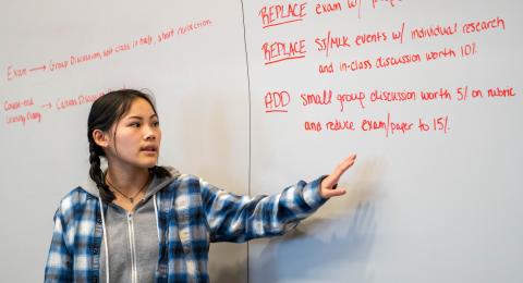A student stands at a whiteboard