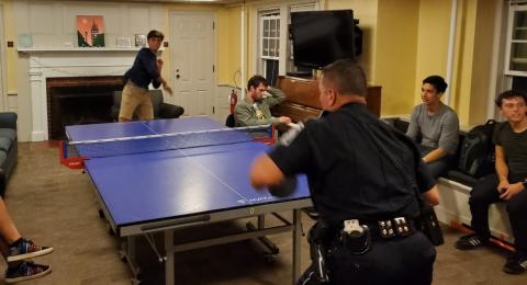 Sawyer Hall - Student playing ping pong with police officer