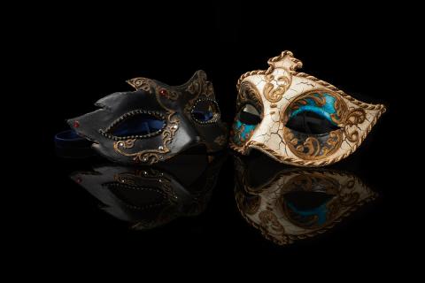 Two masquerade masks on a black background.