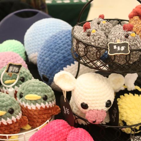 Table with display of crochet ducks, cows, chickens, bees.