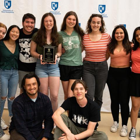 Student org group standing holding award plaque.