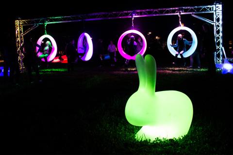 Neon green light-up bunny in the forefront of glow swings.