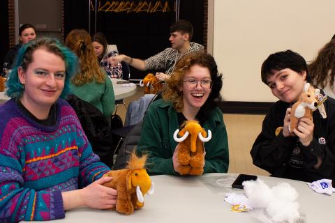 Three students pose with stuffed animals.