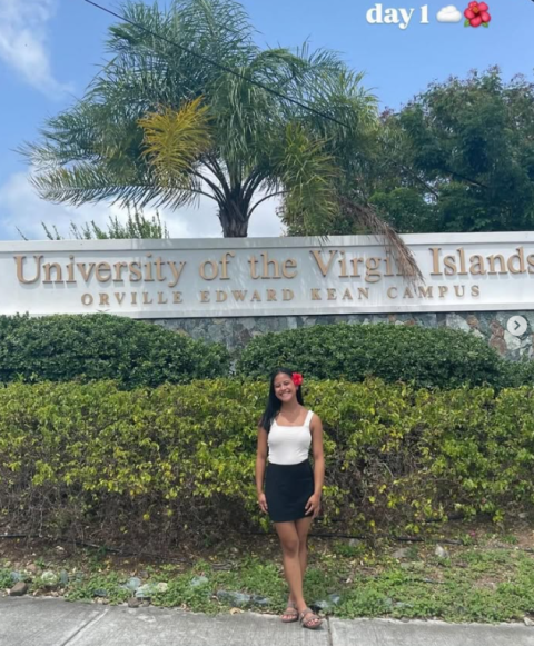 Student pictured in front of campus sign for UVI St. Thomas