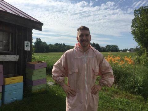 Image of Andrew DeMeo posing in a bee-keeping suit