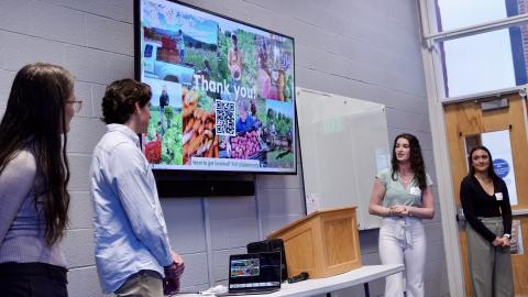 students presenting in front of a screen