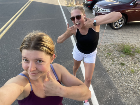 two people smiling with thumbs up