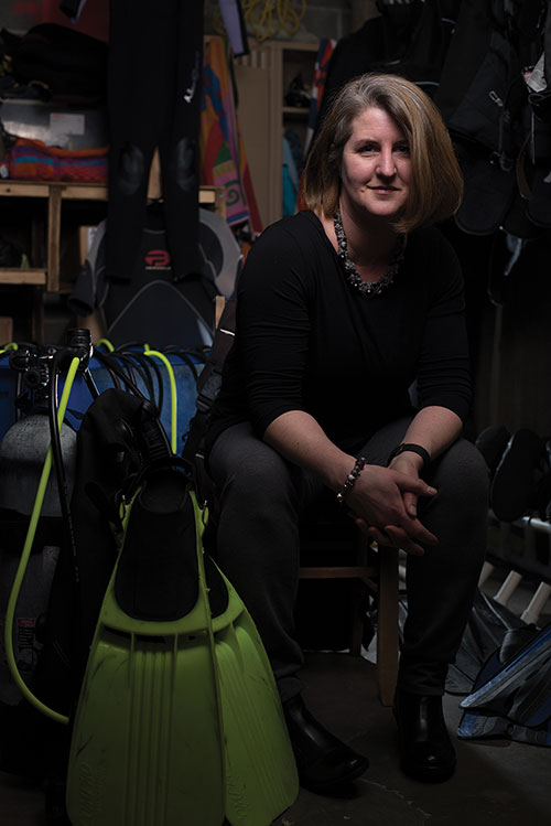 Kristin Duisberg in a closet with some SCUBA gear