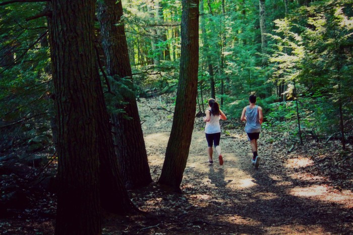Two UNH students running through College Woods