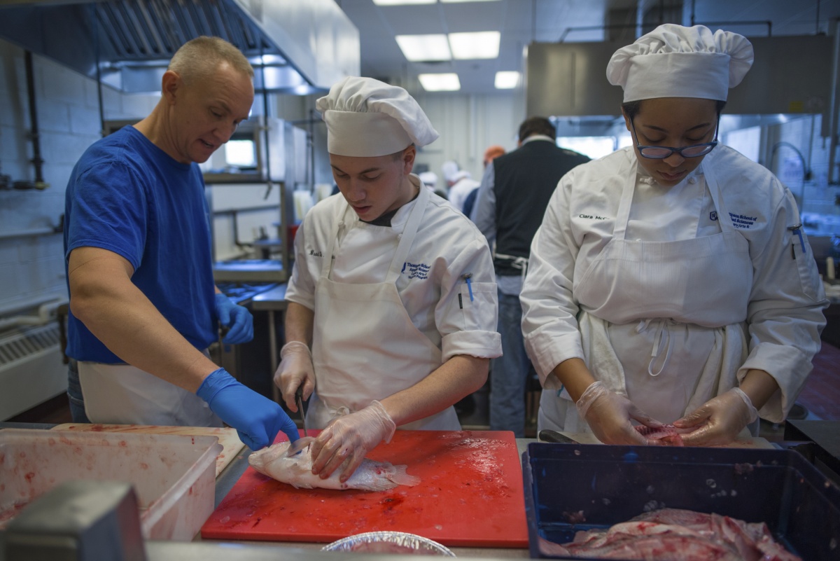 UNH students filleting talapia