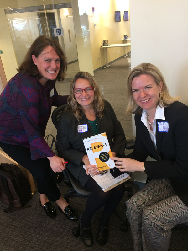 photo of 3 women holding book
