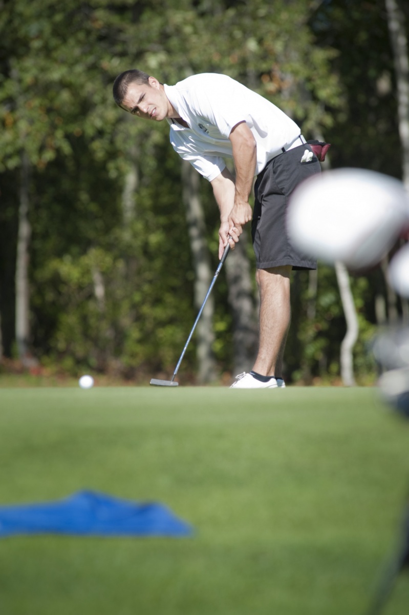 a UNH student golfing