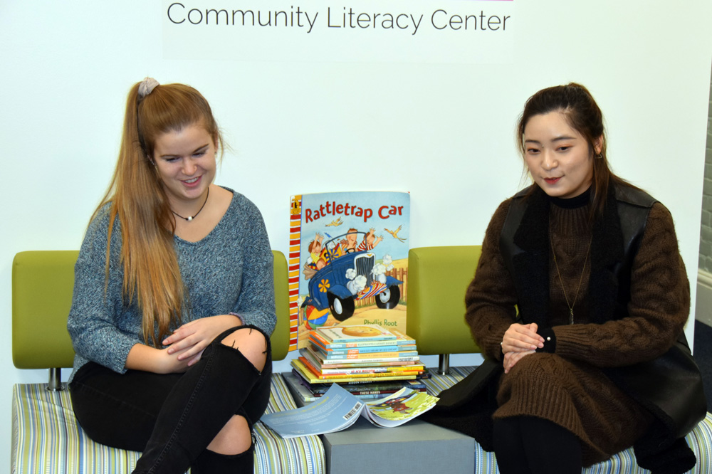 Two UNH students reading to young children 