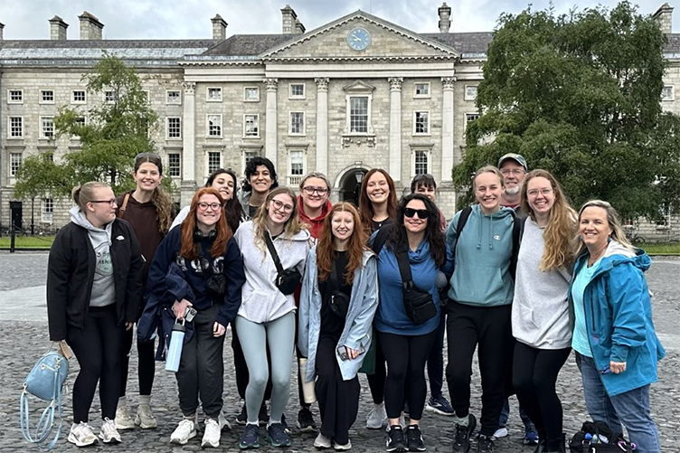 Group of students gather outside of a stone building in Ireland