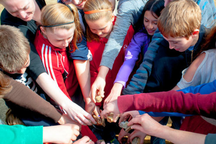 students drop stones into water as part of bullying prevention education