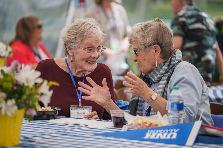 Two women having a conversation at a table during reunion