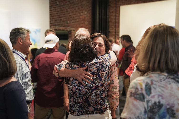 Two attendees hug at reunion