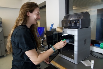 female student removing item from a 3D printer in the CEPS Makerspace