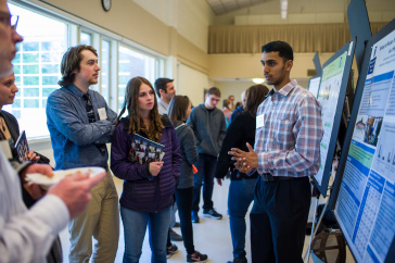 A male UNH student presents his research findings during the 2018 UNH Undergraduate Research Conference