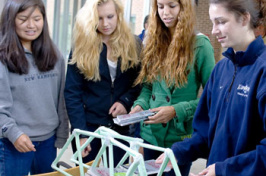 civil engineering students with paper bridge