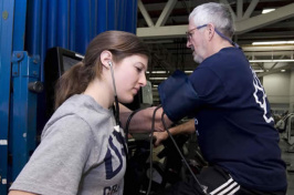 student measuring heartrate of rehab participant