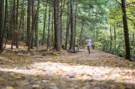 a UNH student running in College Woods