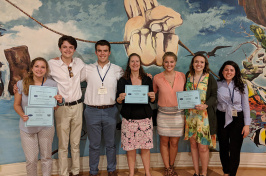 students and leader holding awards