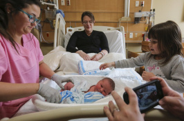 Image of people surrounding a newborn 