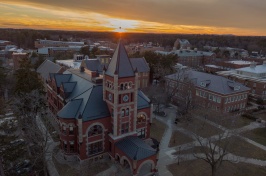 Thompson Hall on UNH campus shot from above, with sun setting behind