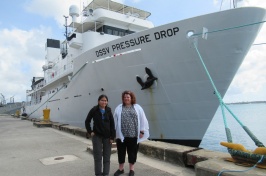 Jaya Roperez and Rochelle Wigley stand on a dock in front of the DSSV Pressure Drop vessel.