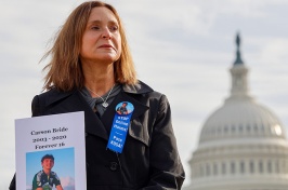 Woman holds a photo of her son outside of the capitol in Washington, D.C.