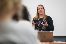 Teacher speaking at the front of a classroom