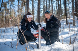 Two female researchers working in a snowy field