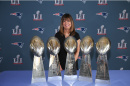Louise Griffin standing in front of Patriots 5 Super Bowl trophies