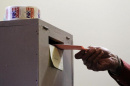 image of voter planning a ballot in box-photo credit: The Boston Globe
