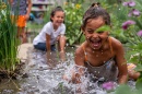 Two children splash in a flooded garden