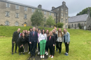 group of students stand together outside an historic building in Ireland