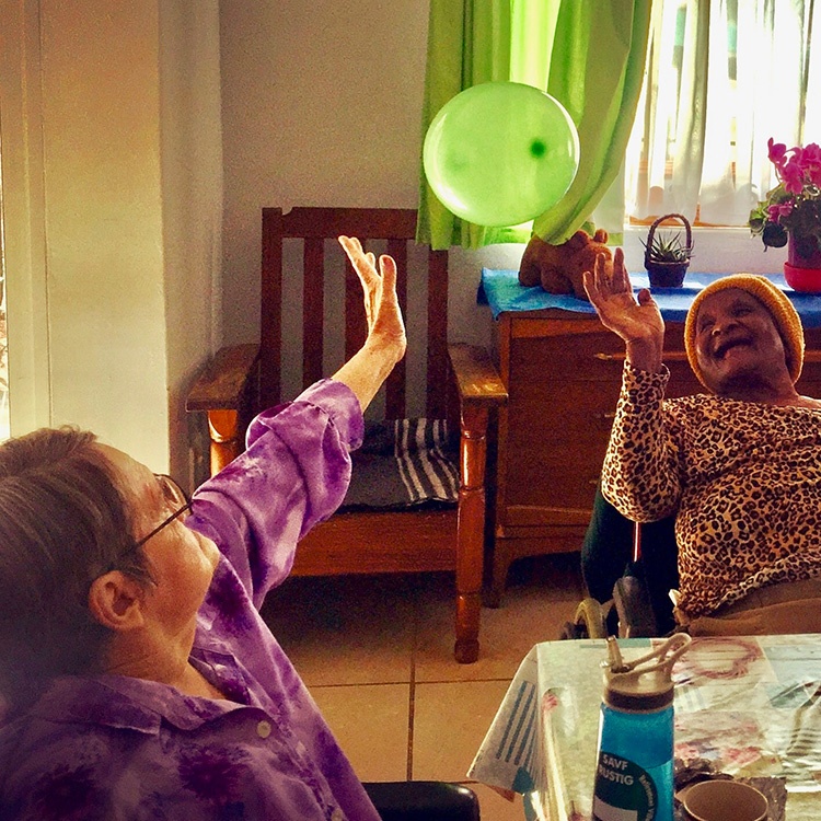 two women vollying a balloon between them