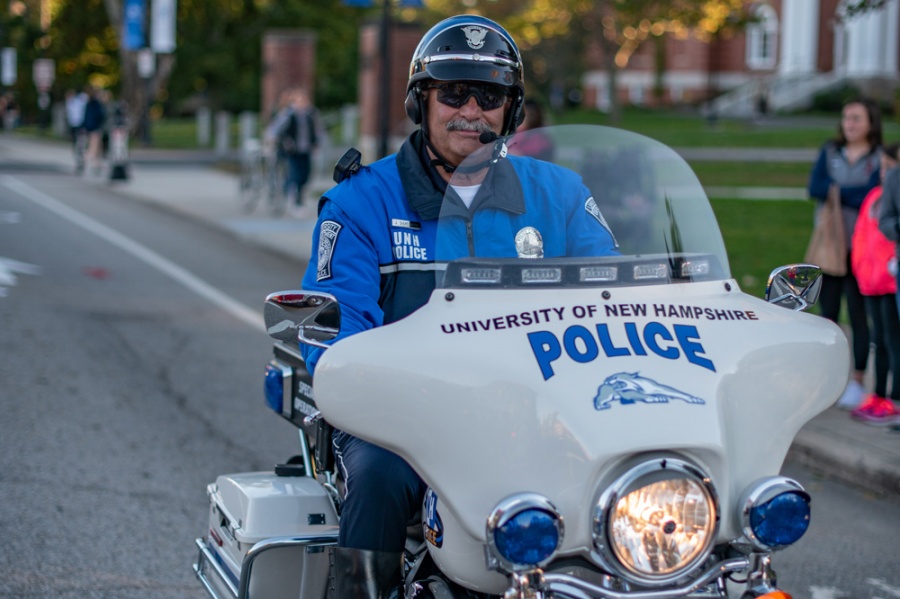 An officer rides a motorcycle in UNH's Homecoming Parade 2018