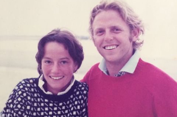 Young couple posing with man's arm around the woman's shoulder